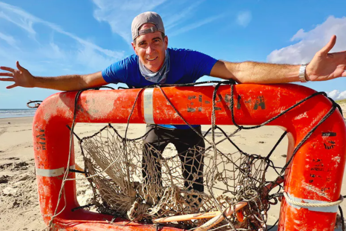 Jace Tunnell on beach with marine debris